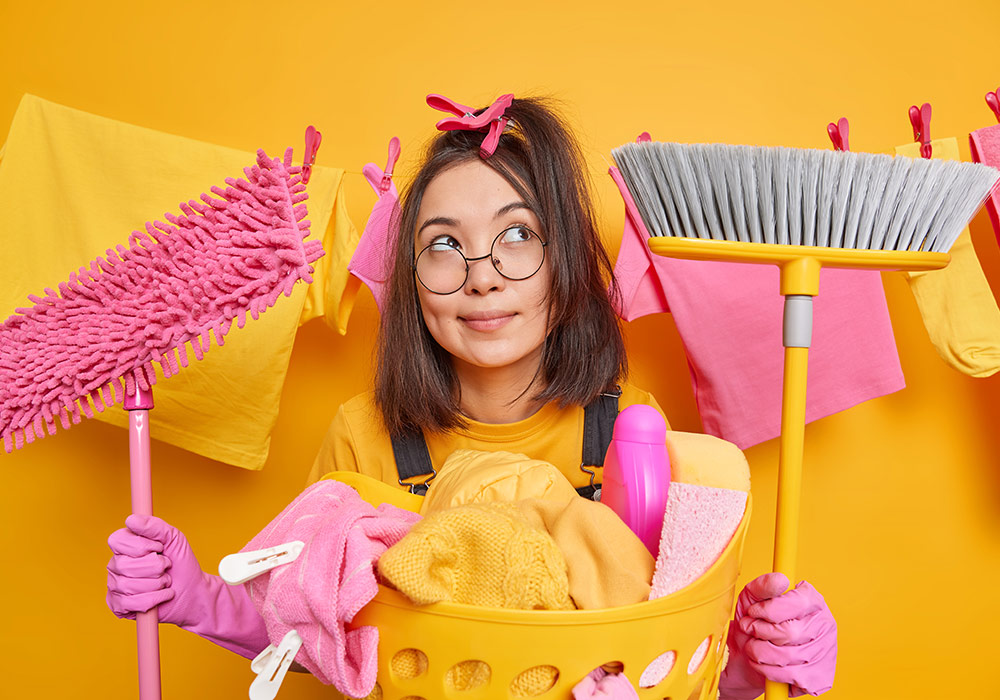 dreamy-woman-stands-with-cleaning-tools-concentrates-thoughtfully-thinks-what-after-finishing-work-about-house-poses-near-basin-laundry-haging-clothesline-domestic-chores