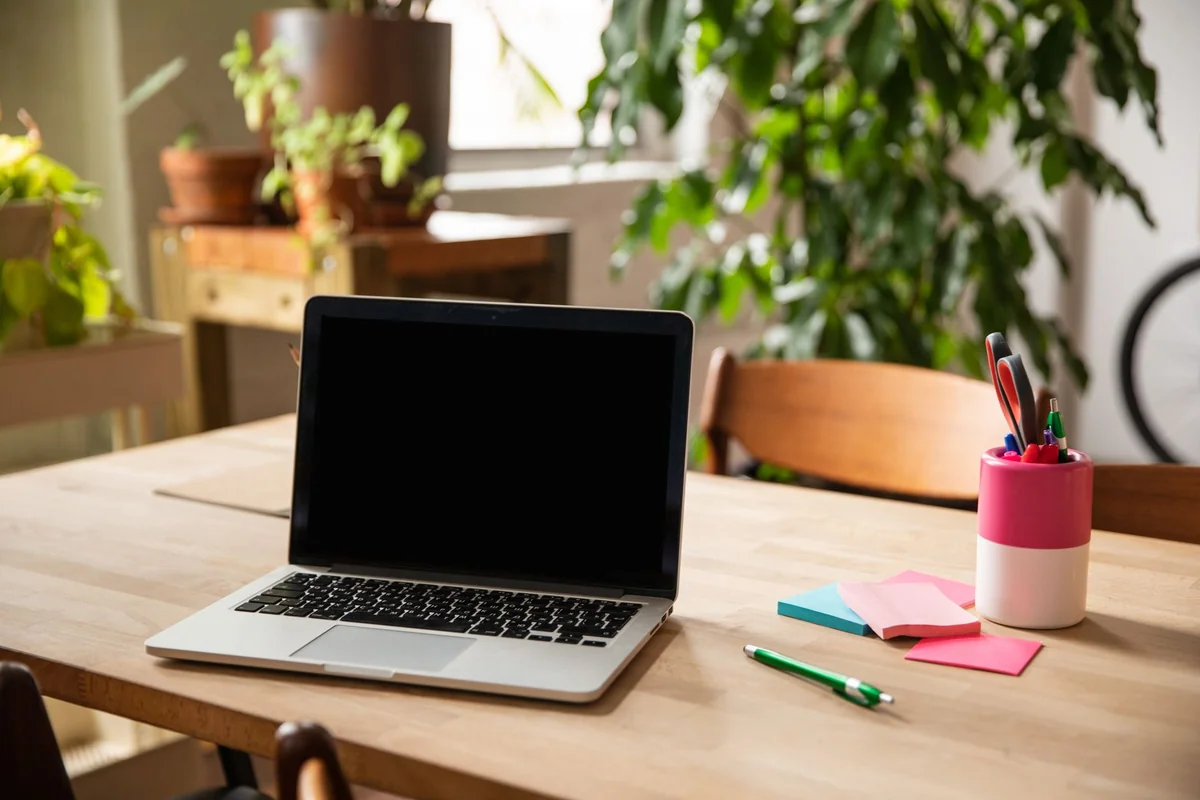 Ordinateur portable posé sur un plan de travail en bois