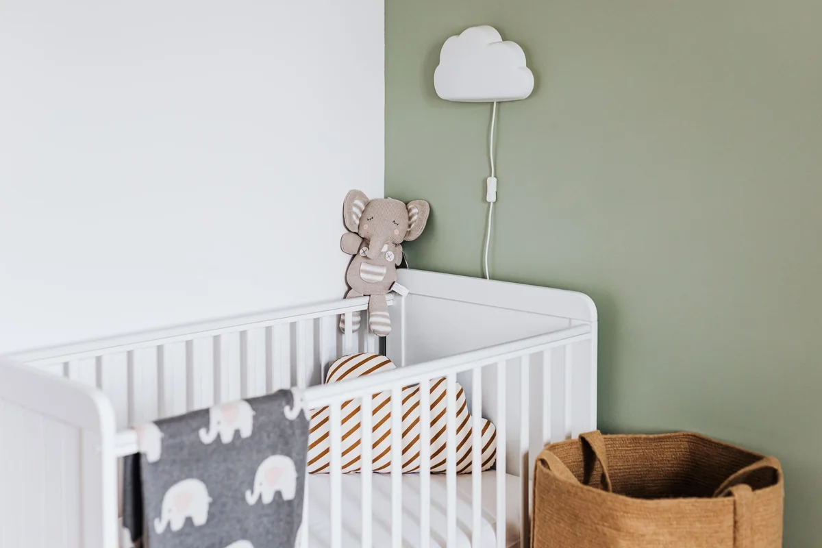 Lit à barreaux dans une chambre de bébé aux tons doux