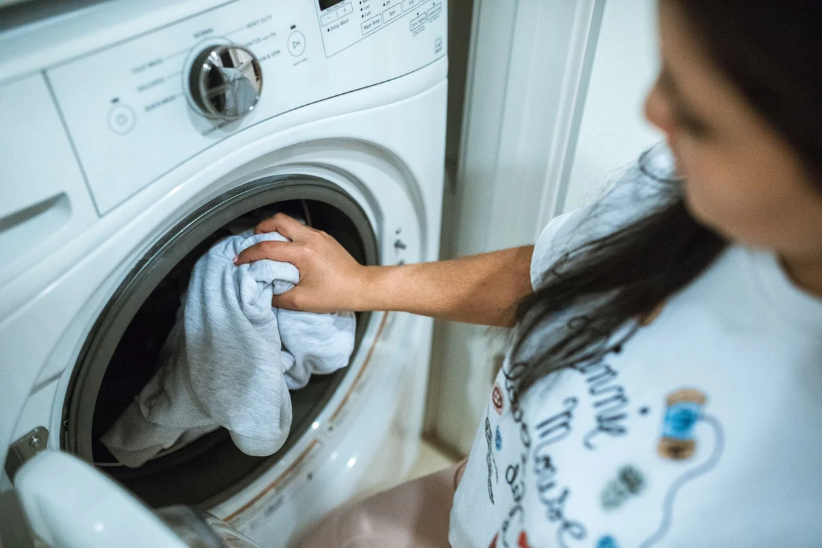 Chargement du linge dans un lave-linge à hublot