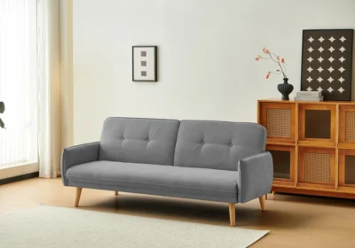 Canapé-lit convertible SERAFIN en tissu gris, pieds en bois naturel, dans un salon lumineux