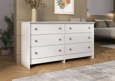 Commode blanche 6 tiroirs à boutons ronds argentés, dans une chambre au parquet en chevrons