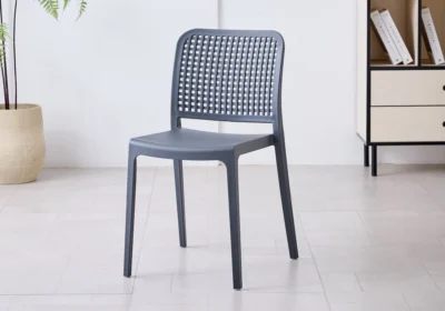 Chaise TESSA en polypropylène gris anthracite, dossier ajouré à motif quadrillé, dans une pièce lumineuse