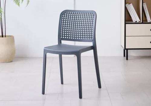 Chaise TESSA en polypropylène gris anthracite, dossier ajouré à motif quadrillé, dans une pièce lumineuse