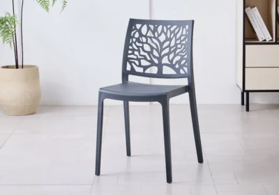 Chaise NOLA en polypropylène gris anthracite, dossier ajouré à motif d'arbre, dans une pièce lumineuse