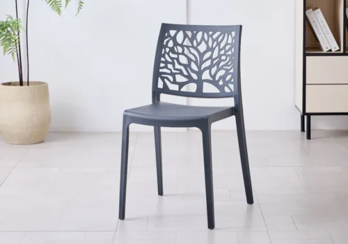 Chaise NOLA en polypropylène gris anthracite, dossier ajouré à motif d'arbre, dans une pièce lumineuse