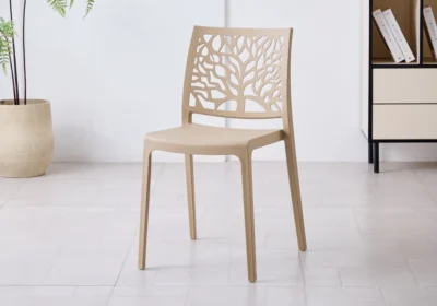 Chaise NOLA en polypropylène beige, dossier ajouré à motif d'arbre, dans une pièce lumineuse
