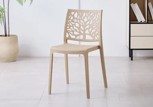 Chaise NOLA en polypropylène beige, dossier ajouré à motif d'arbre, dans une pièce lumineuse