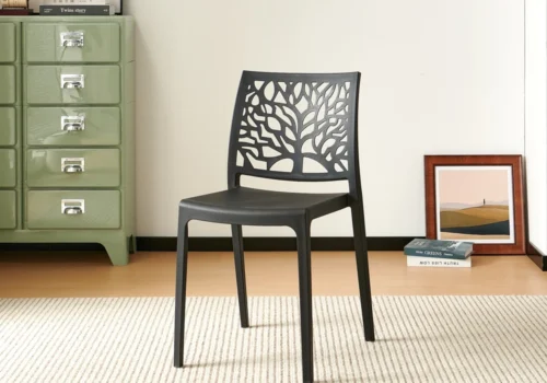 Chaise NOLA en polypropylène noir, dossier ajouré à motif d'arbre, dans une pièce lumineuse